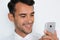 Beautiful close-up portrait of young man using mobile phone on gray background. Businessman speaking on his smart phone.