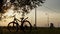 Beautiful close up scene of bicycle at sunset, sun on blue sky with vintage colors, silhouette of bike forward to sun.