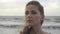 beautiful close up serious and romantic face of woman watching far on sea background