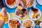 Beautiful close up of table woth gourmet and marine food like fish and chips with hands taking it - group of people eating