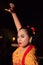 The beautiful closeup face of a Javanese woman with make-up at a traditional dance performance while wearing a yellow costume