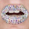 Beautiful closeup with female lips with white colorfull gemstones. Open mouth with white teeth. Make-up, lip art