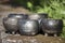 Beautiful closeup of unique planters and bowls of black pottery in summer morning sunlight
