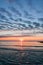 Beautiful cloudy sunrise on Black Sea shore with fisherman on dock