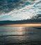 Beautiful cloudy sunrise on Black Sea shore with fisherman on dock