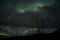 Beautiful colorful aurora borealis dancing on night sky over massive power grid structure