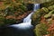 Beautiful colorful background with river and stones in autumn time. White Opava Waterfalls - Jeseniky Mountains - Czech Republic