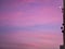 Beautiful colorful clouds at sunset with a moon in the corner of the image. Framed by the edge of the house with satellite