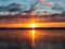 Beautiful colorful sunrise on the freezing weather forming light pillar above sun over the frozen river with beautiful reflection