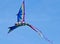 A beautiful, colourful stunt kite, in the blue sky, high up in the wind