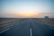Beautiful colourful sunset over endless empty road in middle of desert. Asphalt highway in Tunisia, North Africa.
