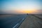 Beautiful colourful sunset over endless empty road in middle of desert. Asphalt highway in Tunisia, North Africa.