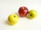 A beautiful combination of yellow, green and red apples on a white background