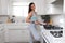 Beautiful commercial model fitness and healthy living portrait, cooking healthy low calorie meal on stove top after exercising