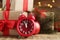 Beautiful composition with alarm clock and Christmas gifts on wooden table, closeup. Boxing day