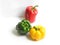 Beautiful composition of fresh bell peppers in glossy green, red and yellow colors on a white background with their lighting and s