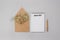 Beautiful composition with notebook with 2021 New Year Goals, wooden pen and kraft paper envelope with tiny flowers, flat lay