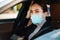 Beautiful confident focused businesswoman in face mask driving car
