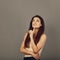 Beautiful confident happy smiling business woman with long healthy brown hair and folded arms in white shirt on grey background