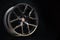 Beautiful and cool aluminum forged wheel, close-up. dark on black background, copyspace. sports style for auto racing and auto