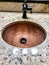 Beautiful copper bathroom sink with marble countertop