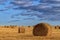 Beautiful countryside landscape. Round straw bales in harvested fields and blue sky with clouds