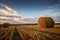 Beautiful countryside landscape. Round straw bales in harvested fields and blue sky with clouds