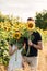 Beautiful couple having fun in sunflowers field. A man and a woman in love walk in a field with sunflowers, a man hugs a woman.