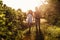 Beautiful couple having fun in sunflowers field. A man and a woman in love walk in a field with sunflowers, a man hugs a woman.