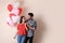 Beautiful couple with heart shaped balloons on background, space for text. Valentine`s day celebration