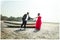 Beautiful couple holding hands by rowboat at beach