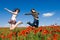 Beautiful couple jumping in the poppy field