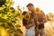 Beautiful couple is kissing in sunflowers field at sunset. A man and a woman in love walk in a field with sunflowers, a man hugs a