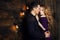 Beautiful couple in love hugging against the background of glowing lights. Studio portrait photo of a girl blondes and a guy with