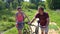 Beautiful couple in love to ride a bike in the woods. Modern young couple gives outdoors