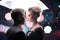 Beautiful couple man with woman with white umbrella in flash lights and rain drops