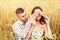 Beautiful couple resting on a wheat field. Loving girl and her boyfriend together. Love concept