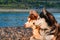 Beautiful couple Siberian husky dogs against a calm river in warm summer evening.