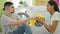 Beautiful couple sitting together on laundry room floor, smelling dirty clothes, embracing household chores with love & confidence