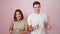 Beautiful couple smiling confident dancing over isolated pink background