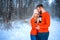 Beautiful couple standing arm in arm in the red sweater in the background of the forest in winter , a walk in the winter woods