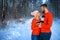 Beautiful couple standing arm in arm in the red sweater in the background of the forest in winter , a walk in the winter woods