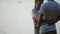 Beautiful couple standing on the shore of the lake and talking. Young couple hugging on the beach on sunset in evening.