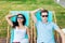 A beautiful couple in the sunglasses is lying on the deck chairs on the lawn in the nice summer cafe. Entertainment