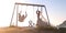 Beautiful couple together on swings at sunset.