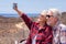 Beautiful couple of travelers enjoying outdoors excursion taking a selfie. Horizon over sea and sunny day