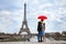 Beautiful couple with umbrella near Eiffel Tower