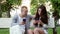 Beautiful couple uses the phone on a bench in the park, shopping online