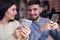 Beautiful couple using telephones at cafe