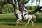 Beautiful cowgirl ride her horse in woods glade